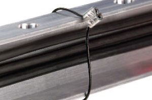 A close up of a metal rail with a Heyco Sunbundler Cable Tie 10" attached to it.