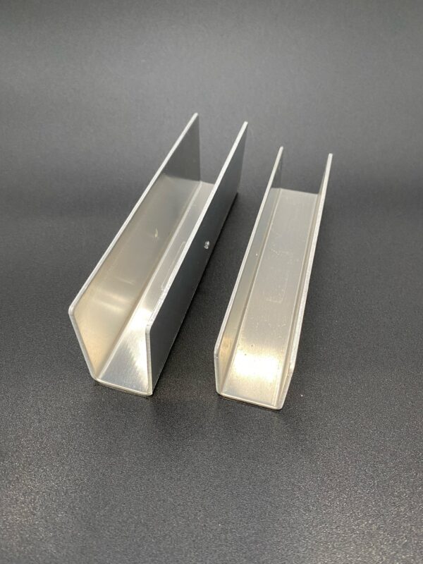 Two aluminum channel sections on a surface.